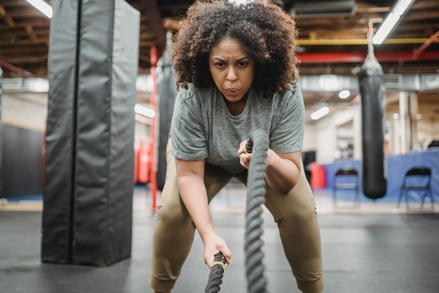 A woman at the gym doing exercise with ropes